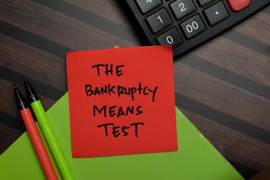 Image of a red note that says The Bankruptcy Means Test next to a calculator.