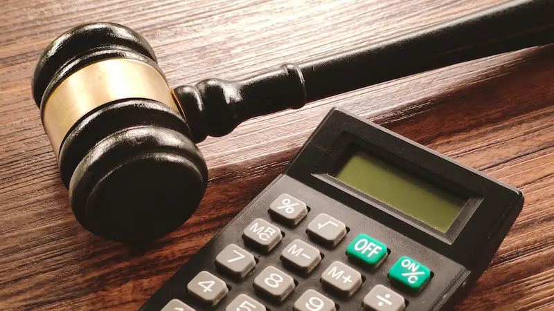 Judge's gavel beside a calculator, representing a chapter 7 means test calculator for bankruptcy eligibility.